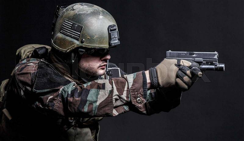 United states Marine Corps special operations command Marsoc raider with pistol. Studio shot of Marine Special Operator black background, stock photo