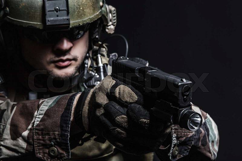 United states Marine Corps special operations command Marsoc raider with pistol. Studio shot of Marine Special Operator black background, stock photo