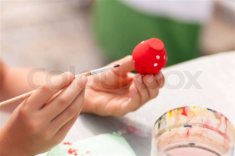 Child paints paints toy from clay closeup, stock photo