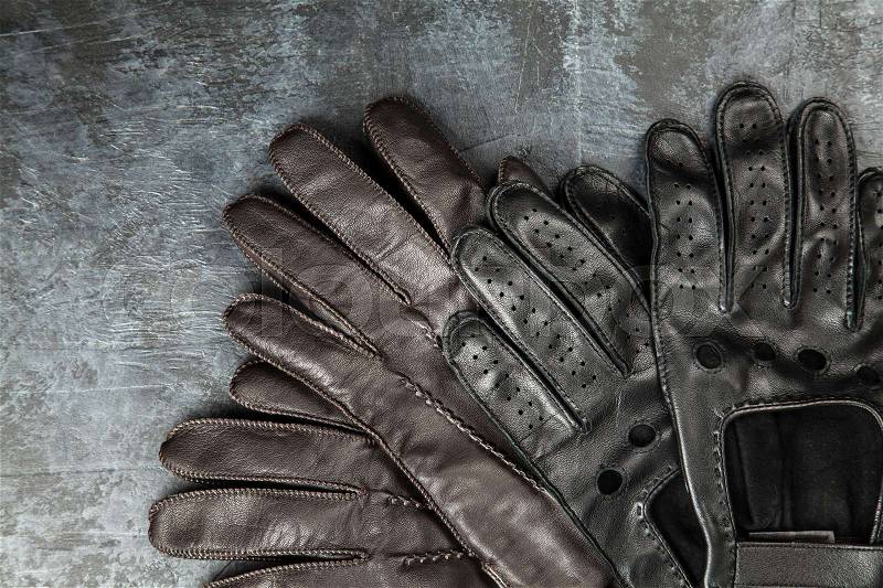 Two pairs of leather gloves on dark background, stock photo