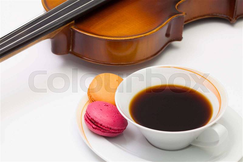 Music break - Old violin, cup of coffee and traditional french colorful macarons on the white table, stock photo