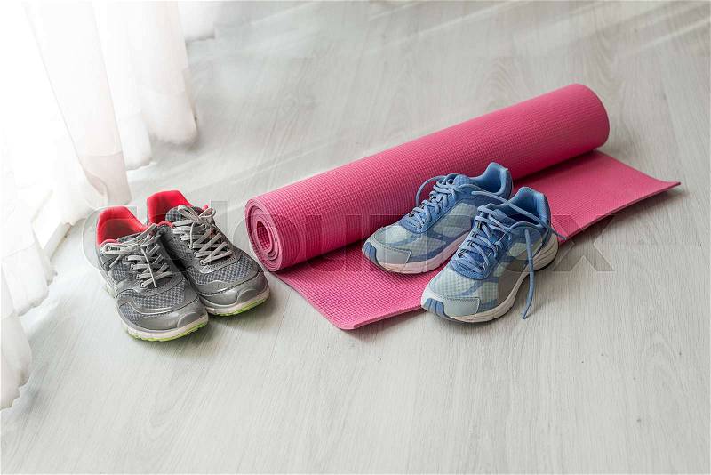 Dirty sport shoes on floor with yoga mat at home. Lifestyle concept. Copy space, stock photo
