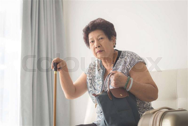 Asian senior woman sitting at home and ready to travel, stock photo
