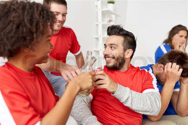 Sport, people, friendship and entertainment concept - happy football fans or friends drinking beer and celebrating victory at home, stock photo