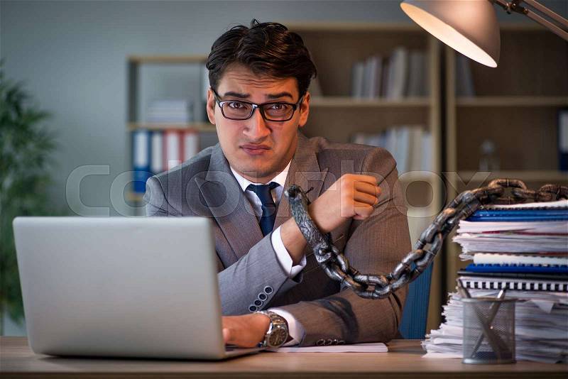 Businessman staying in the office for long hours, stock photo