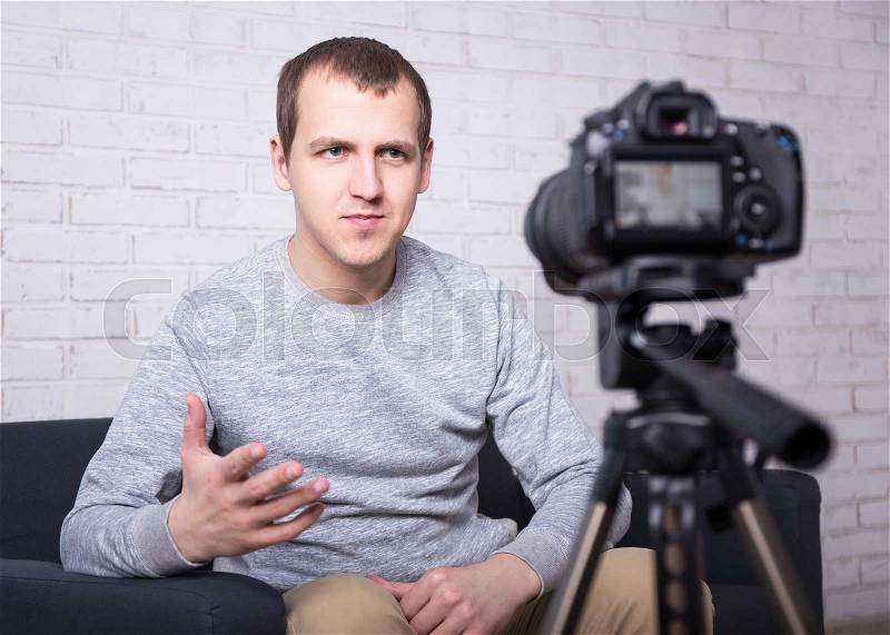 Male video blogger making new video at home, stock photo