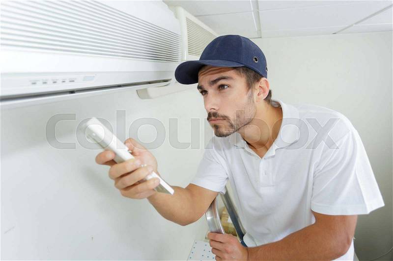 Technician checking ac installation in clients building, stock photo