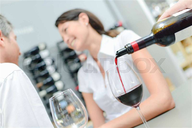 Pouring red wine for couple on a date, stock photo