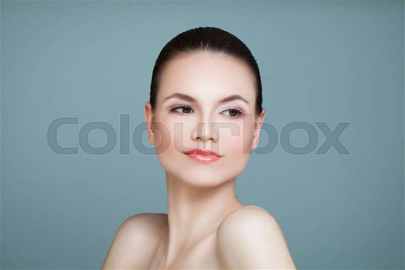 Healthy Woman with Cute Face and Clear Skin on Blue Background. Young Beauty, stock photo