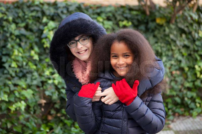 Two happy girls in the park with coats, stock photo