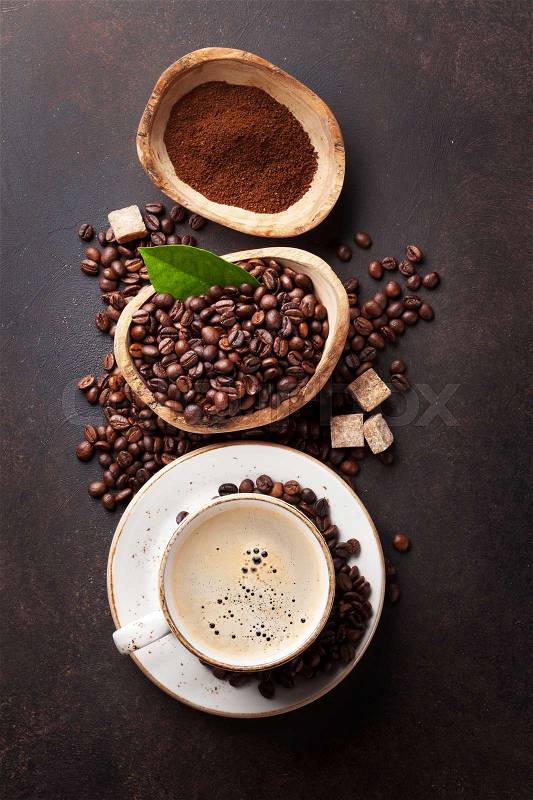 Coffee cup, beans and ground powder on stone background. Top view, stock photo