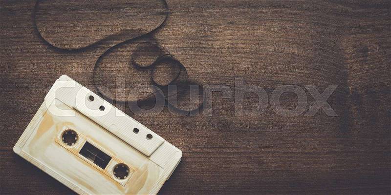 Old retro audio cassette over wooden background, stock photo