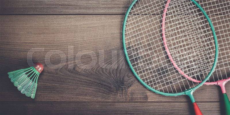 Shuttlecock and badminton racket on wooden background, stock photo