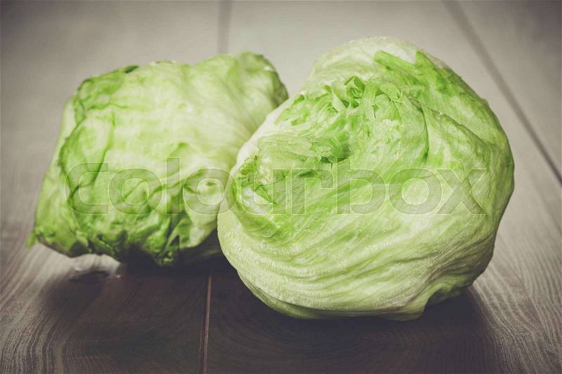 Fresh green iceberg salad on wooden table, stock photo
