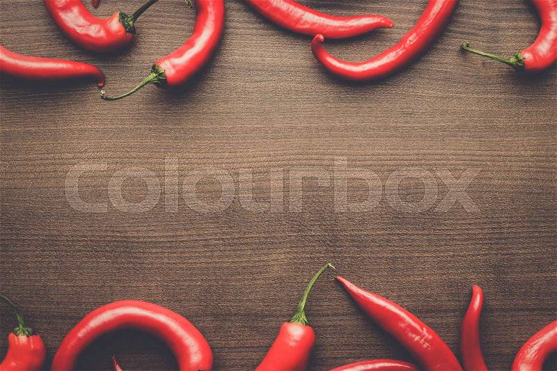Red hot chilli peppers on the wooden table with copy space, stock photo