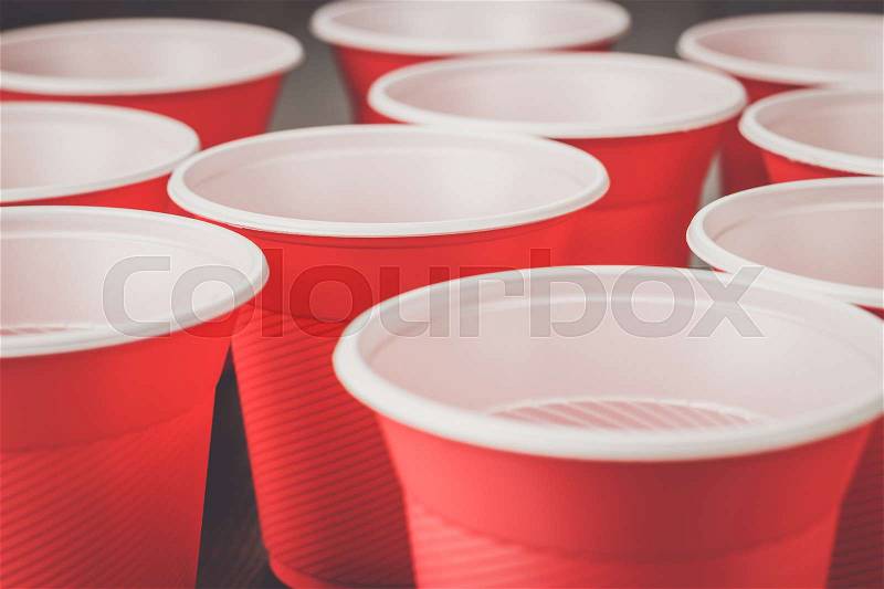 Disposable red plastic cups on the wooden table, stock photo