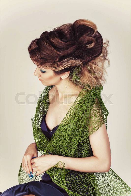 Beautiful Fashion Model with Big Hairstyle in green mesh and blue dress. Woman with long blue nails, stock photo