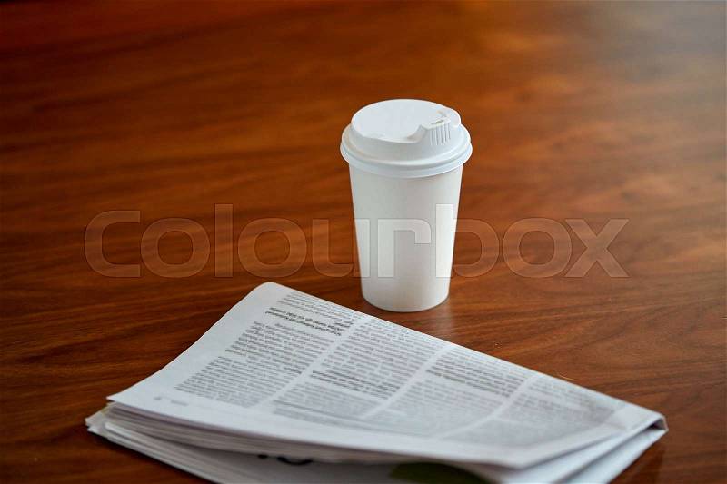 Break, mass media and news concept - coffee drink in paper cup and newspaper on table, stock photo