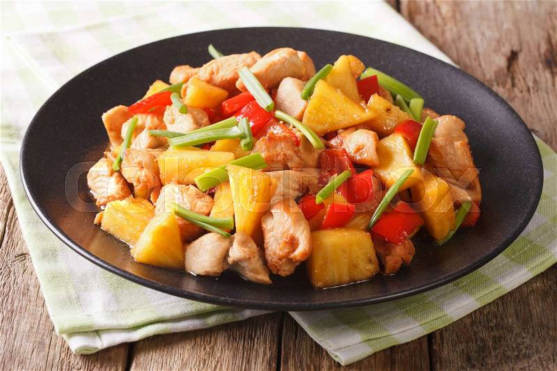 Roasted chicken breast with pineapple and vegetables in sweet and sour sauce on a plate close-up. horizontal , stock photo