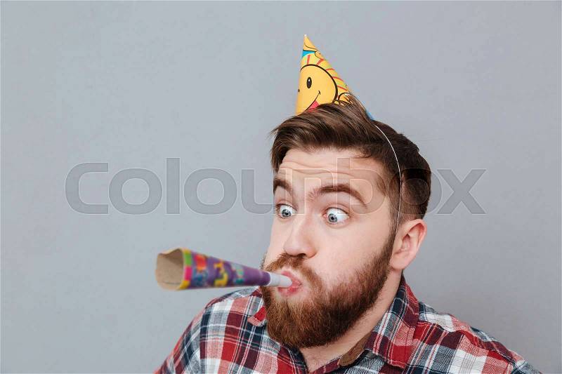 Image of cheerful young bearded birthday man standing over grey background, stock photo