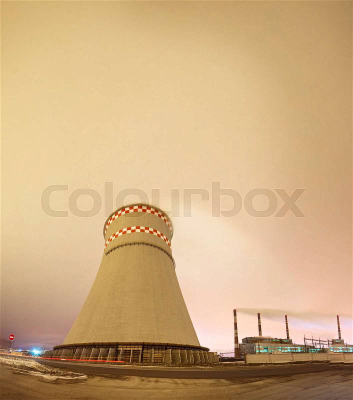Thermal power plant and cooling towers at night near the city, stock photo