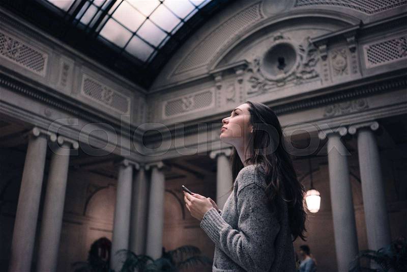 Portrait of a young attractive woman tourist visiting museum or gallery, stock photo