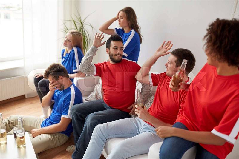 People, leisure, rivalry and sport concept - happy and sad friends or football fans drinking beer and watching soccer game or match at home, stock photo