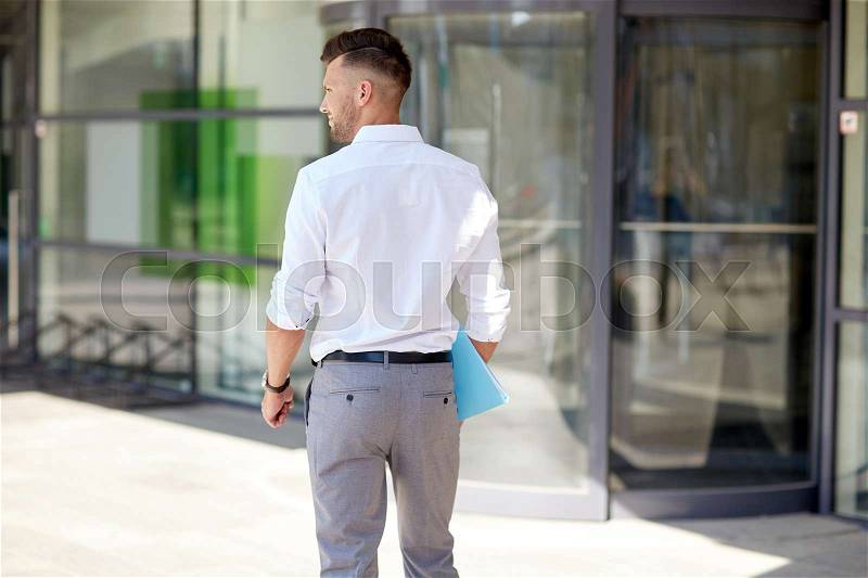 Business and people concept - young man with folder on city street, stock photo