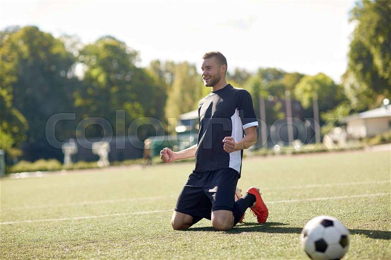 Sport, football, win and people - happy soccer player with on field, stock photo