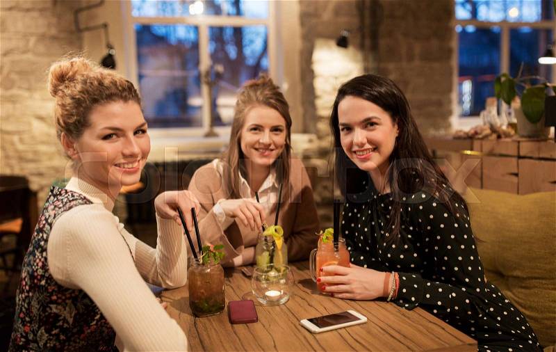 Leisure, celebration, party, people and holidays concept - happy friends with drinks at restaurant, stock photo