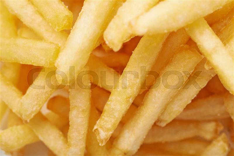 Close-up fragment of a multiple french fries potato chips as a food backdrop composition, stock photo