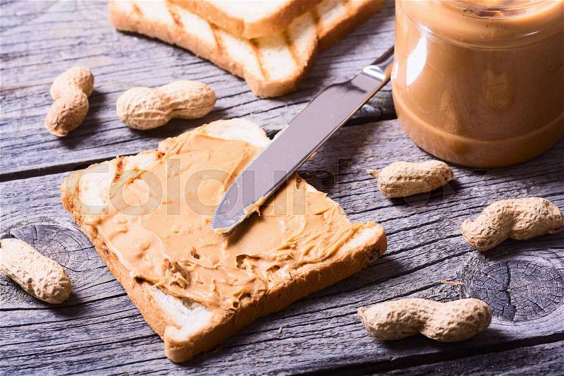 Peanut butter sandwiches or toasts on wooden background, stock photo