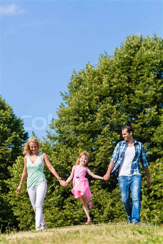 Mum, Dad and daughter running on a country lane, stock photo