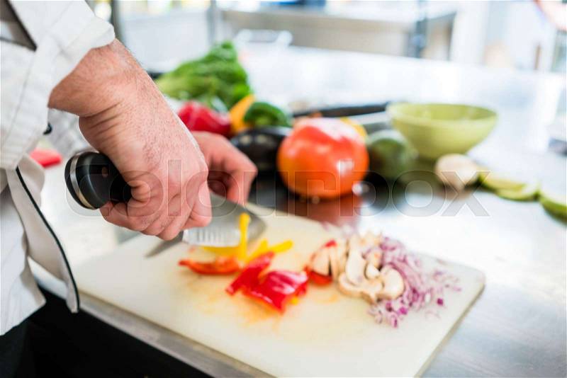 Chef cutting onions and vegetable to prepare for cooking, stock photo