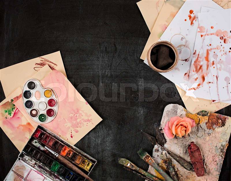 The paint brushes and tubes of oil paints on wooden background, stock photo