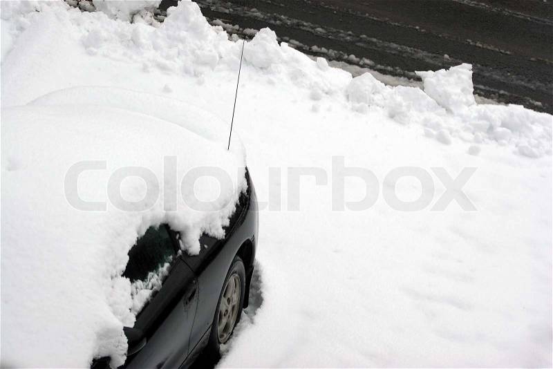 A vehicle covered in snow and snowed in just after the city plow passed the driveway, stock photo