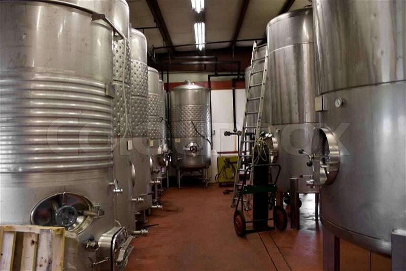 Modern aluminum barrels where grape juice is aged into wine located in a vineyard cellar, stock photo