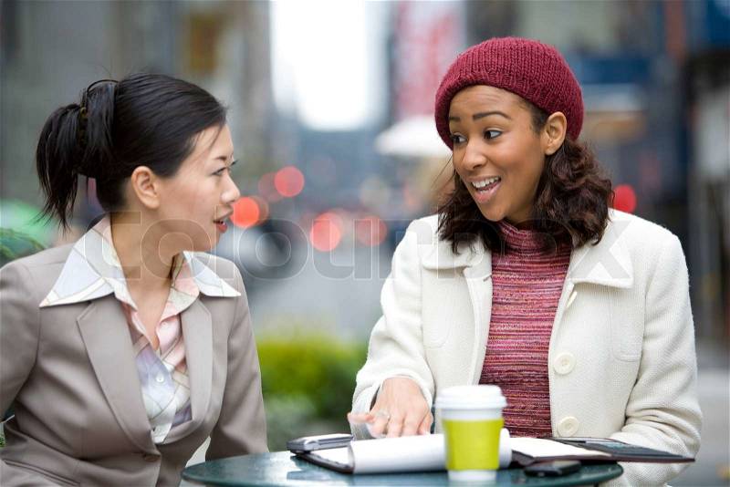 Two business women having a casual meeting or discussion in the city, stock photo