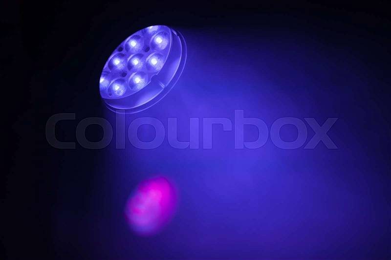 Stage LED spot light with purple blue beam, modern stage illumination equipment, stock photo