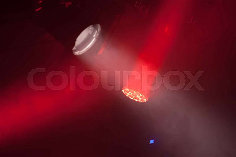 Stage spot lights with red beams in smoke, stage illumination equipment, stock photo