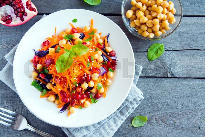 Chickpea and veggie salad with carrots, red cabbage, pomegranate seeds and fresh basil - healthy homemade vegan vegetarian diet detox salad meal food, stock photo