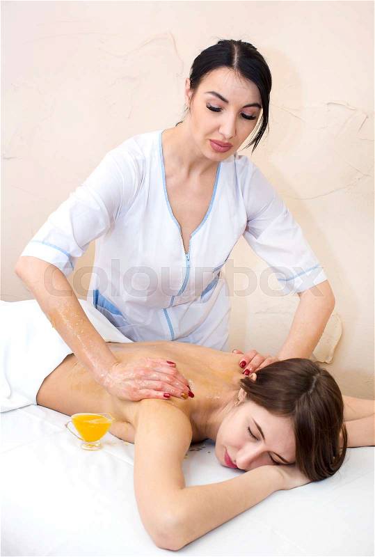 Girl treatment massage honey body wrap in a beauty salon, stock photo