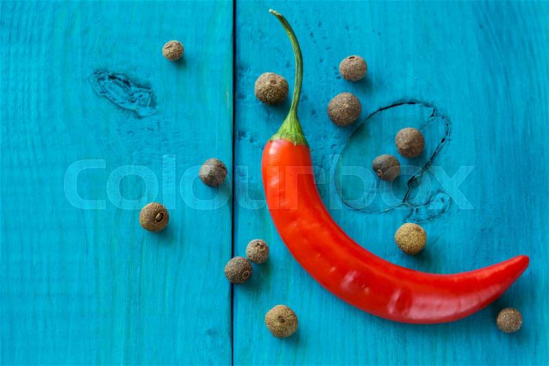 Red chili peppers and spicy pepper, on a wooden blue background, stock photo