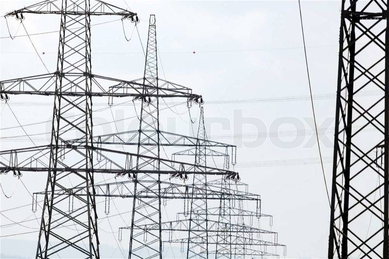 Many power poles of a power line Pylons in front of the open sky, stock photo