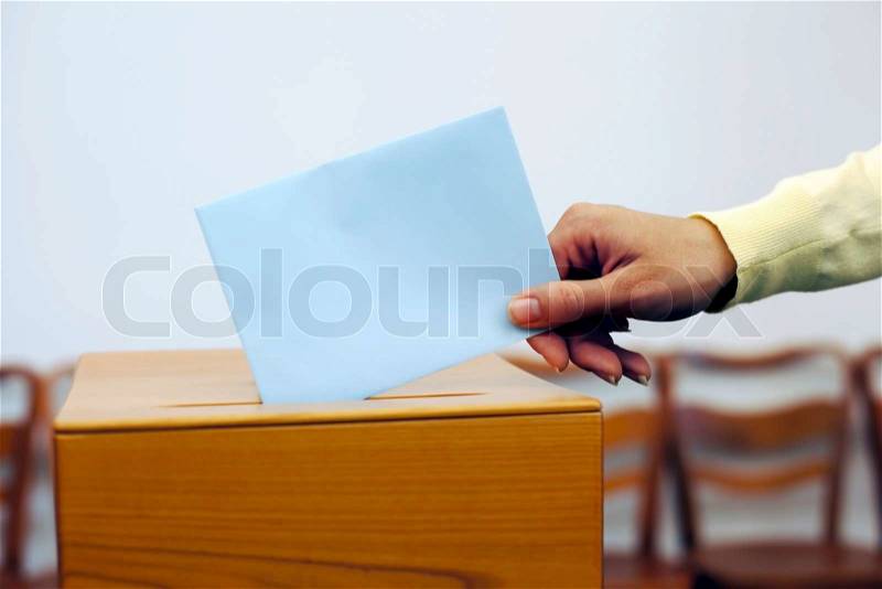 A young woman with a voter in the voting booth Voting in a democracy, stock photo