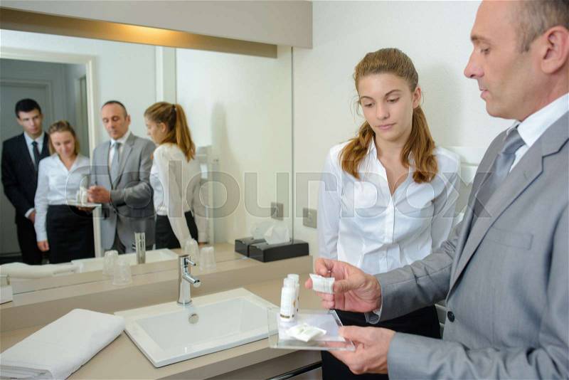 Hotel staff learning bathroom products, stock photo