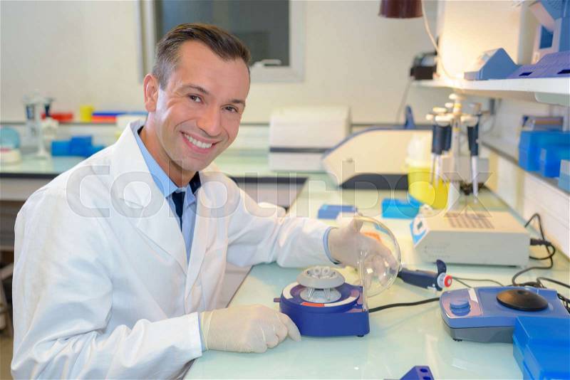 Happy young male researcher working in his lab, stock photo