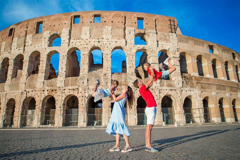 Happy family in Europe. Parents and kids in Rome over Coliseum background, stock photo