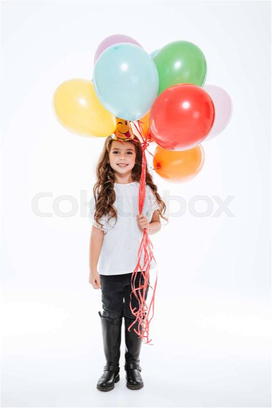 Happy little girl in birthday hat holding colorful balloons, stock photo