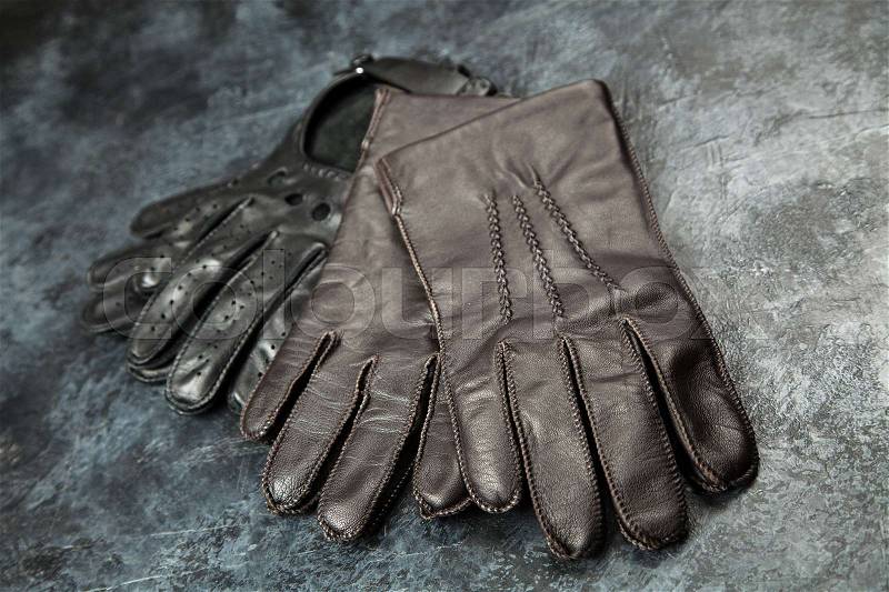 Two pairs of leather gloves on dark background, stock photo
